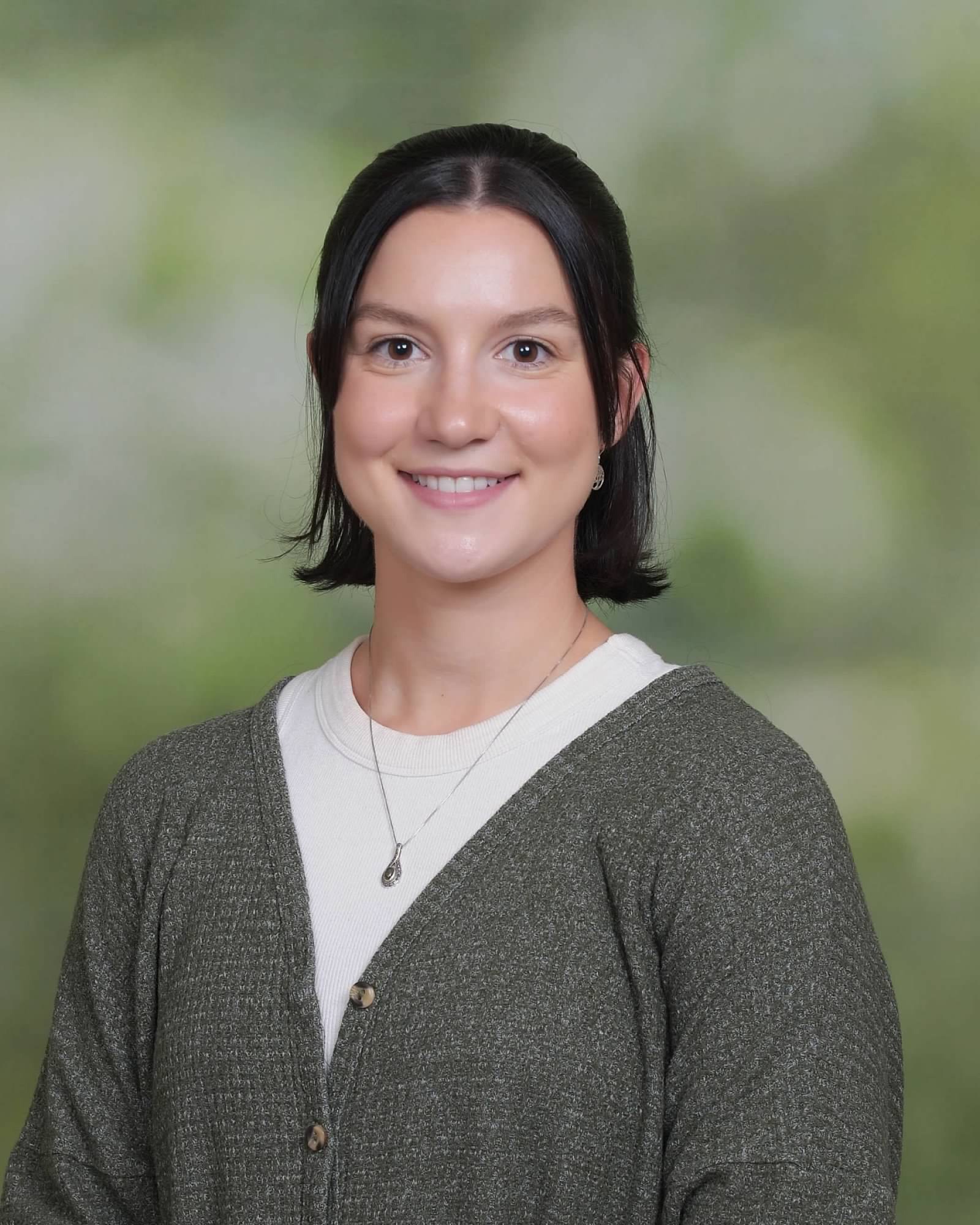 Brianna Richards professional headshot.  Facing into camera, wearing a white shirt and grey cardigan.  